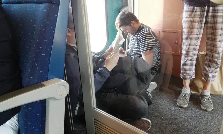 Эти пассажиры предпочли сидеть на полу тамбура, чем на сидении рядом с темнокожими парнями. Фото Алексея Минина.